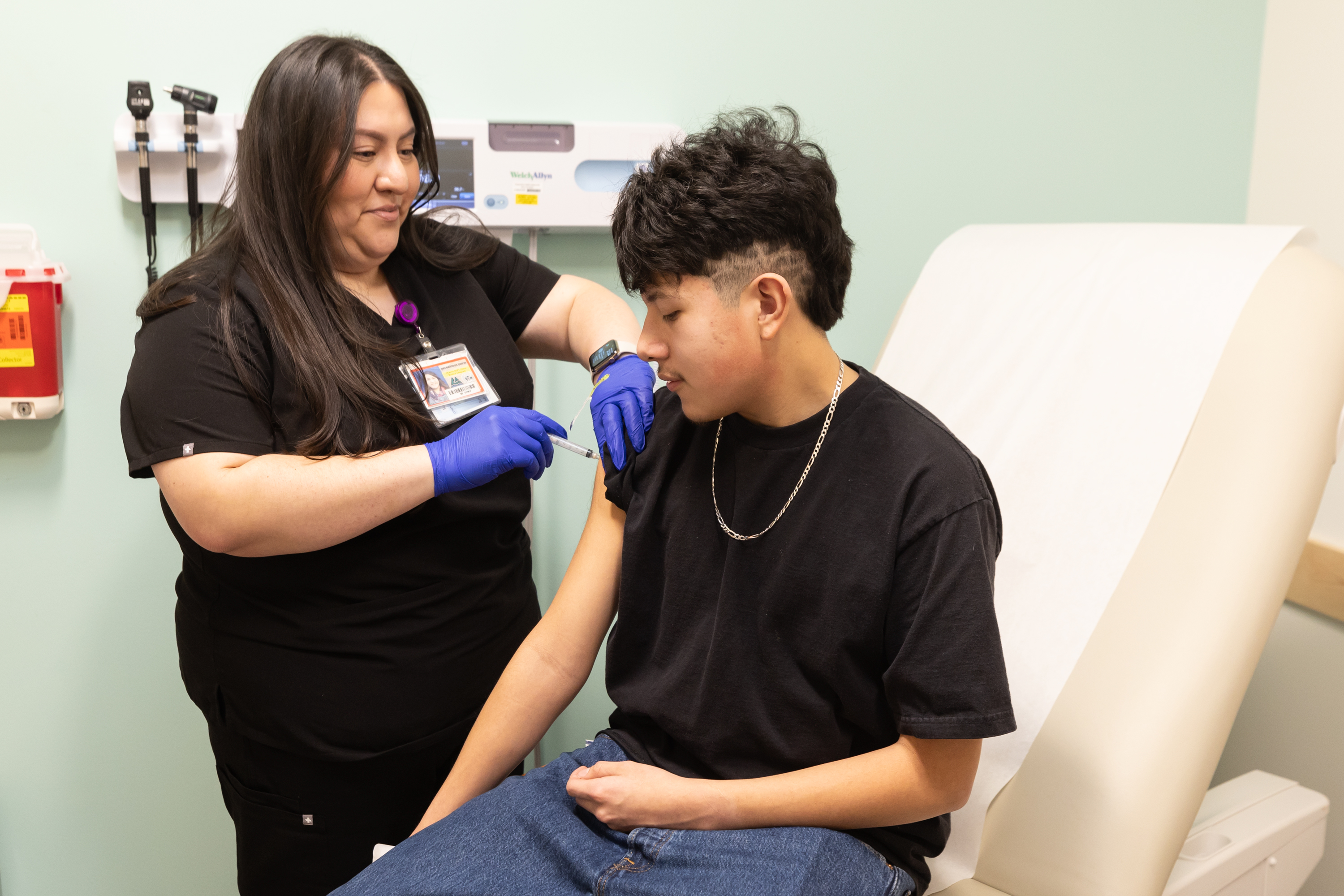 A Student Health Center team member gives a student a shot.