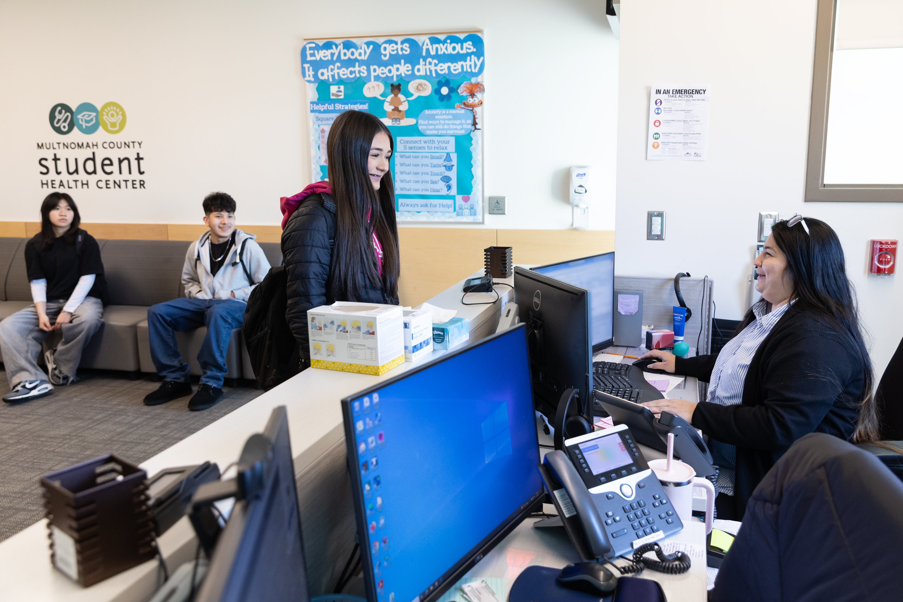 student speaking with receptionist at a student health center 