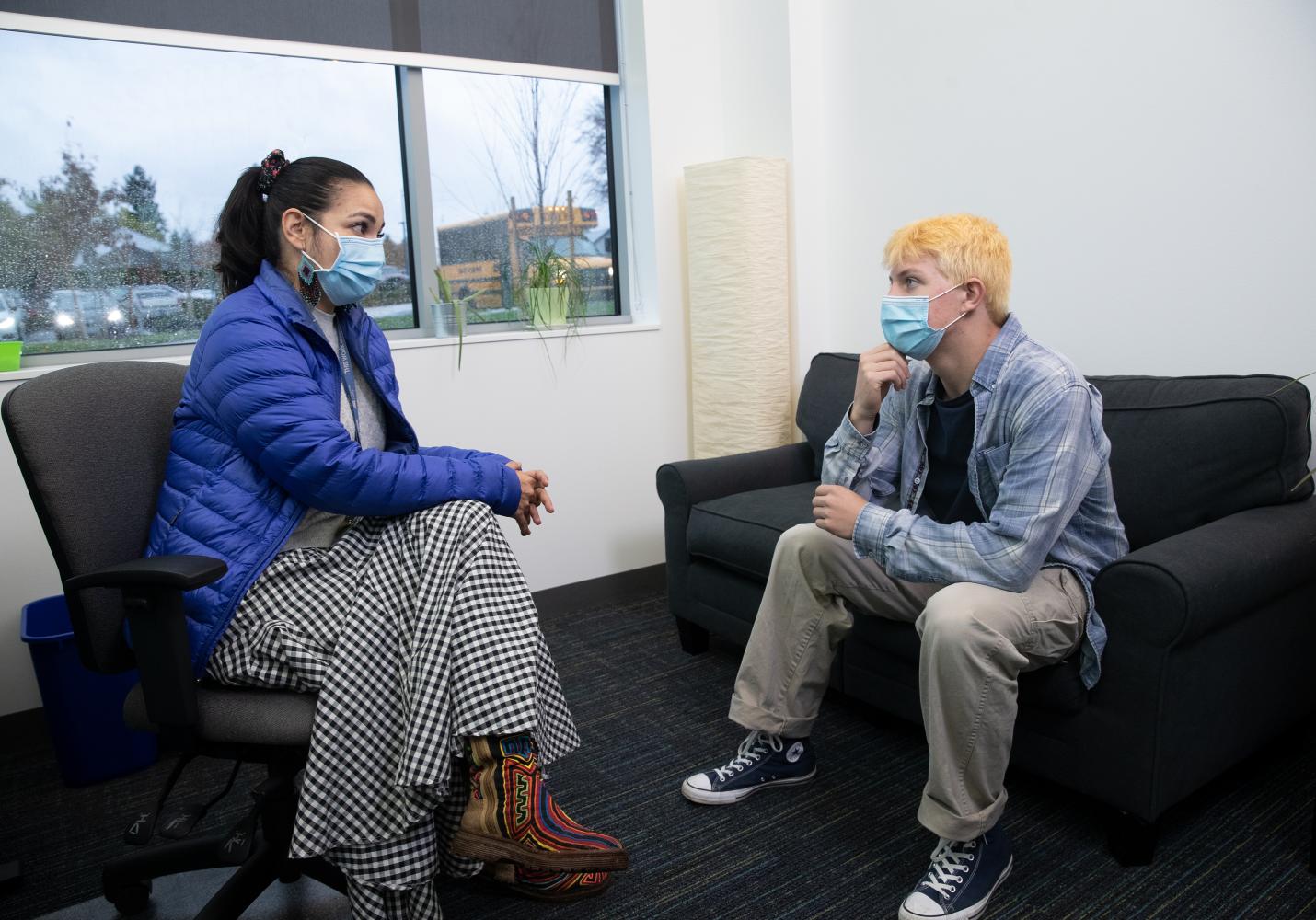 Two people chat while sitting in a Student Health Center.