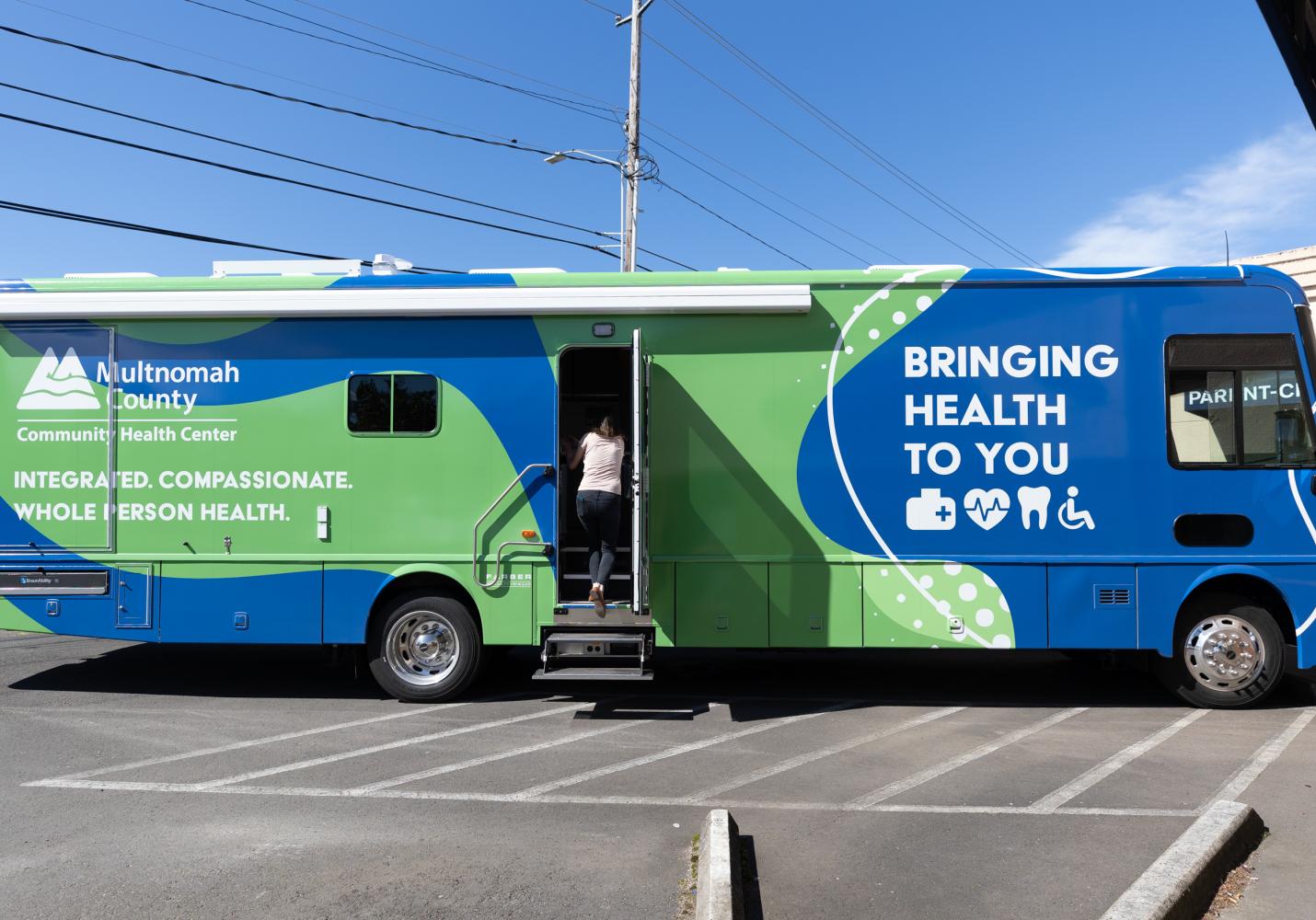 A mobile clinic medical van displays the message Bringing Health to You.