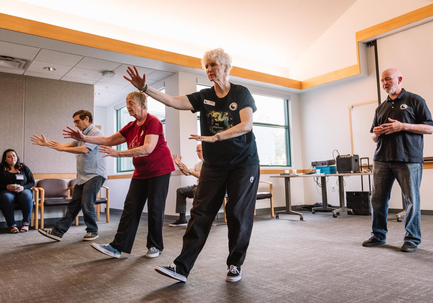 A group of older adults exercise together at a community event.