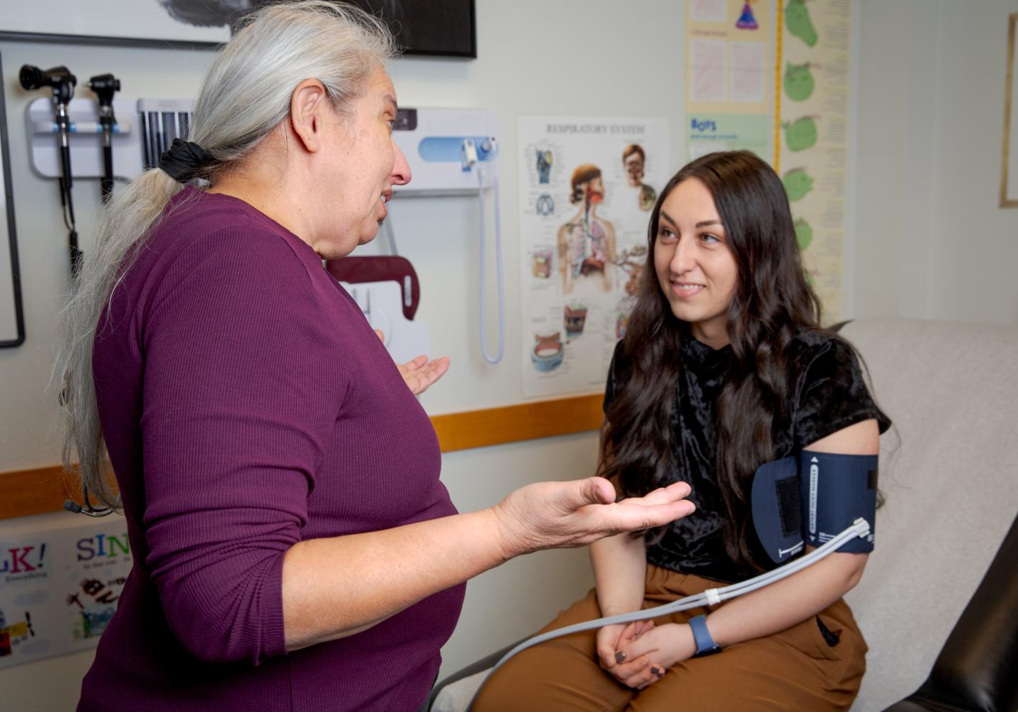 A health care team member checks a patient's blood pressure.