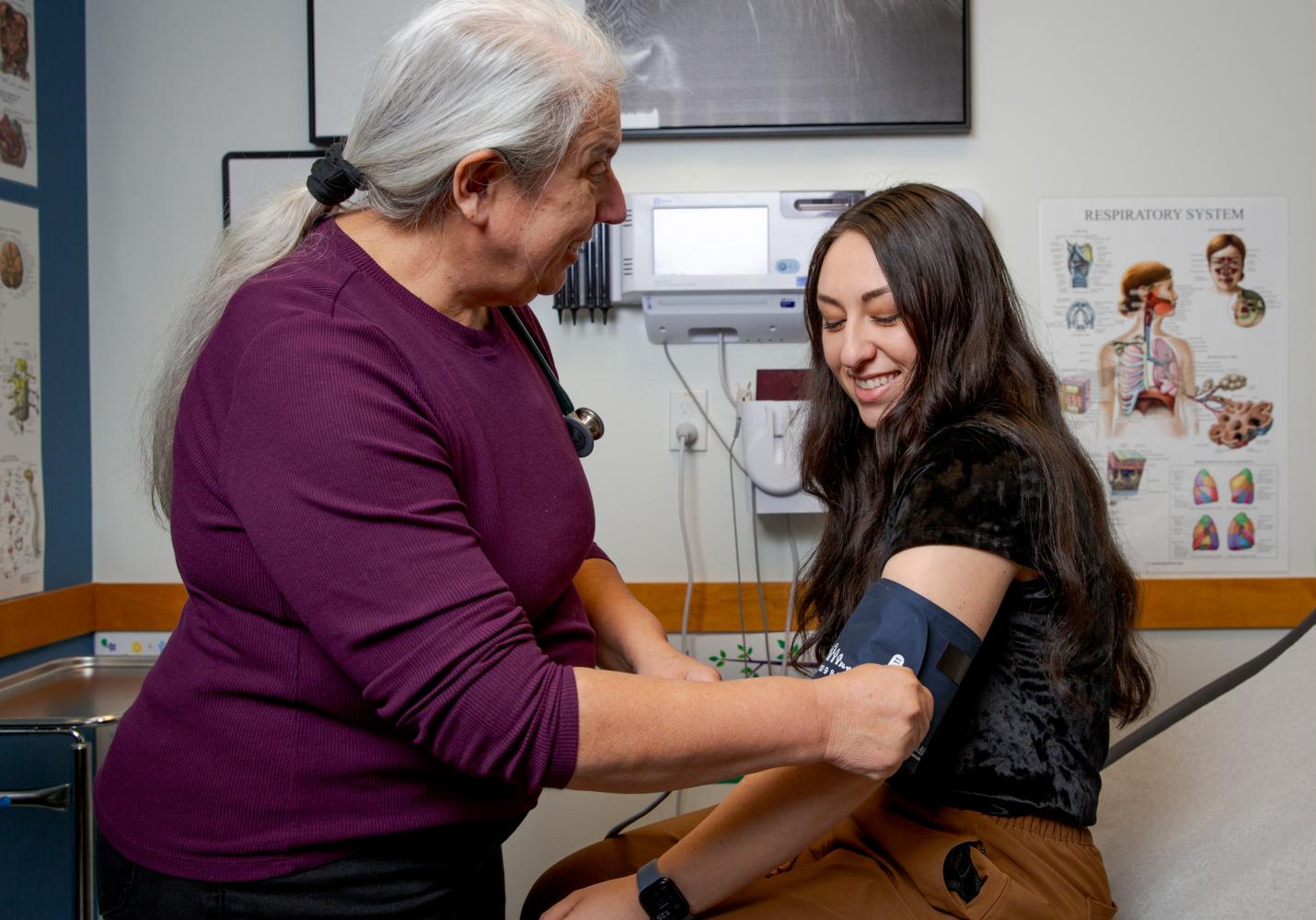 A health care team member checks a patient's blood pressure.