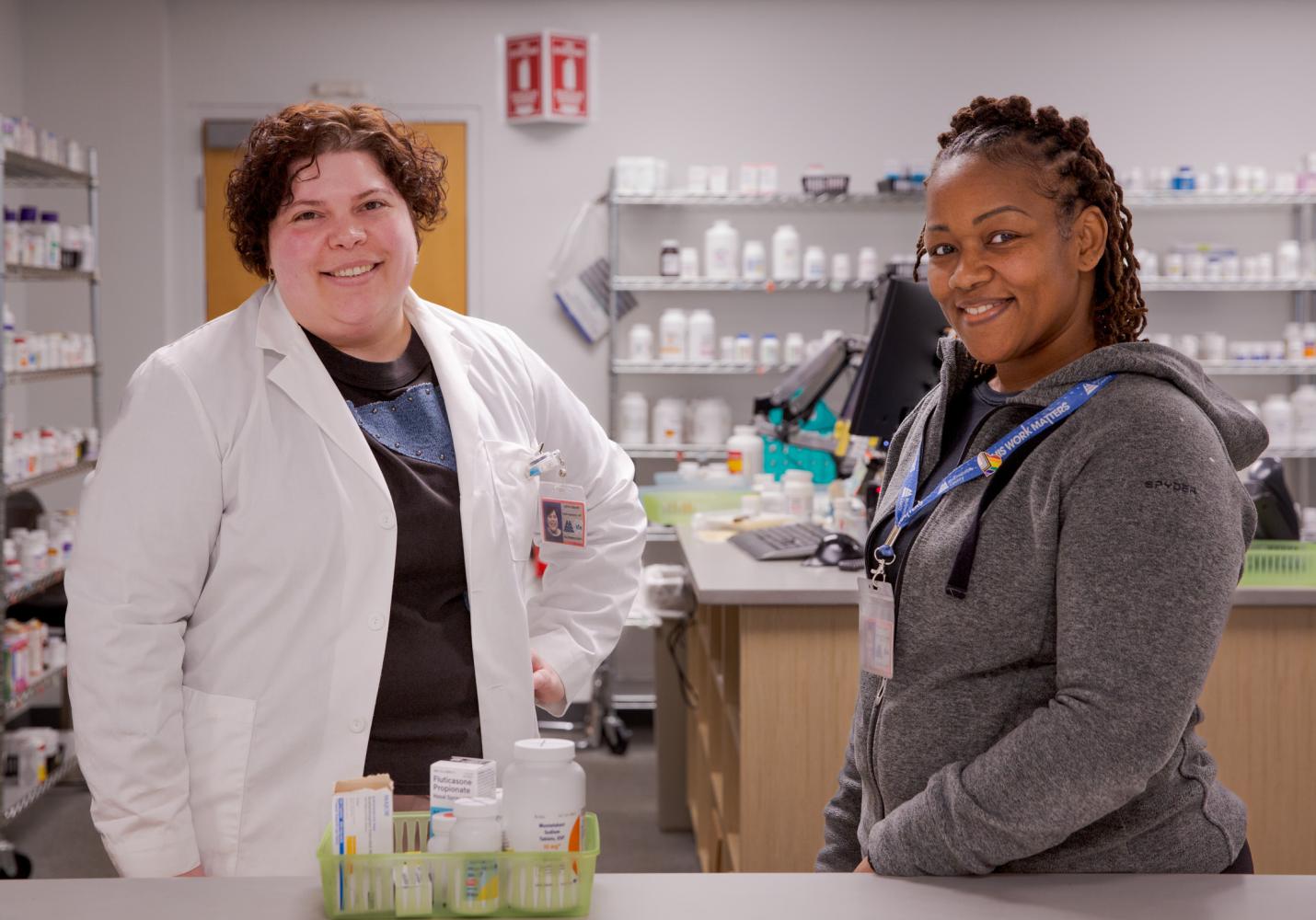 Pharmacy staff smile while working in the pharmacy