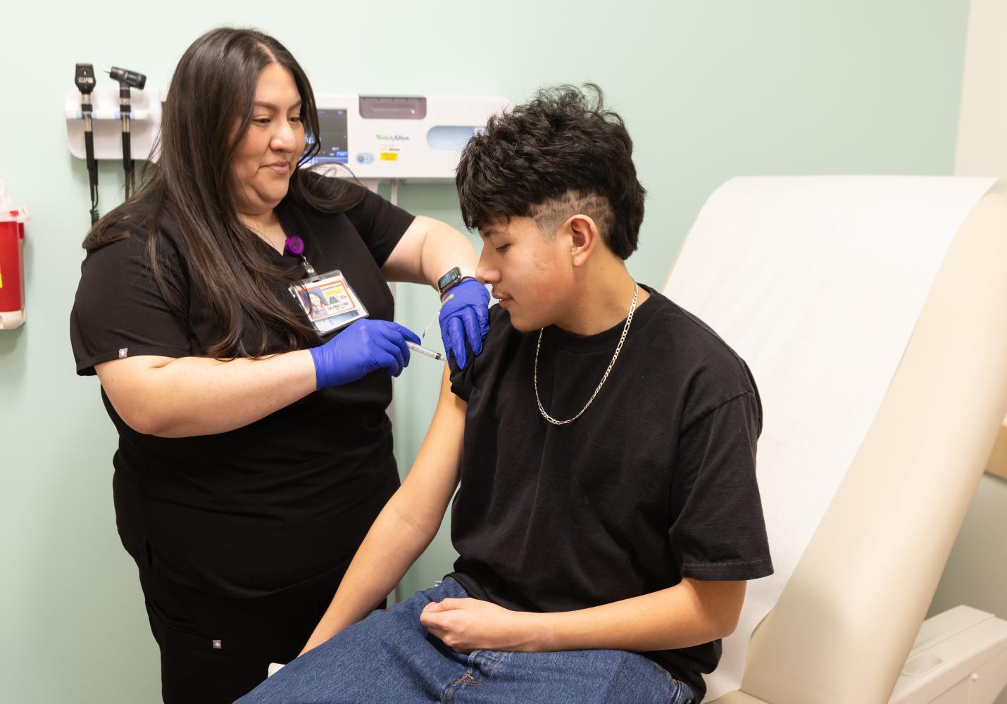 A Student Health Center team member gives a student a shot.
