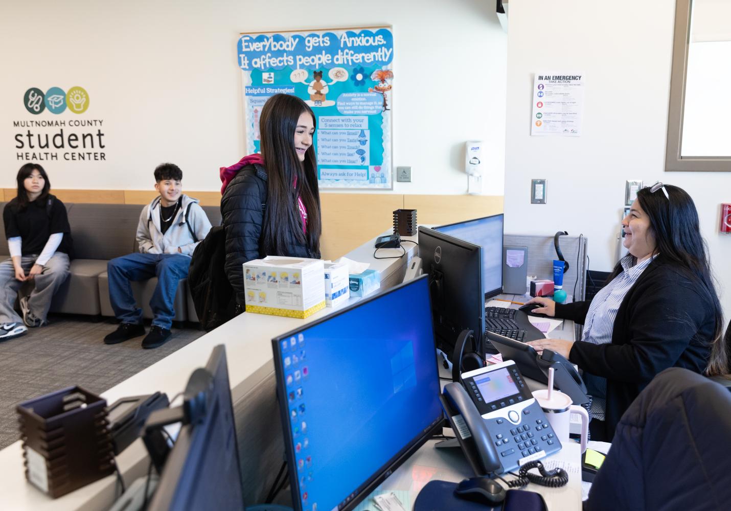 student speaking with receptionist at a student health center 